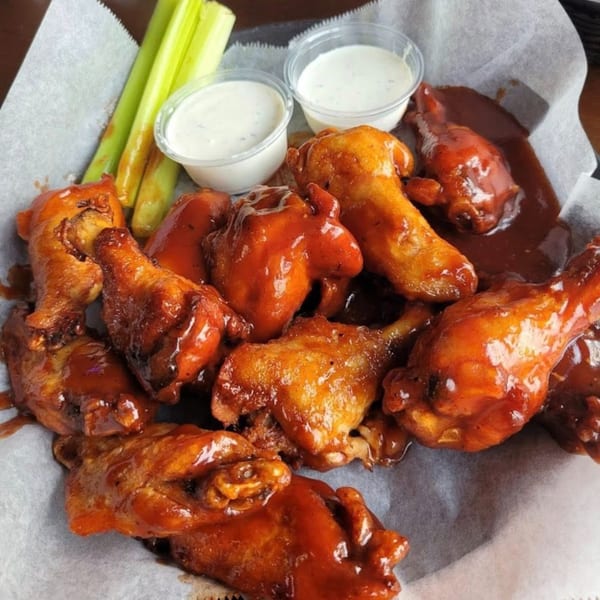 Baked's BBQ chicken wings with celery sticks and two cups of ranch dressing.